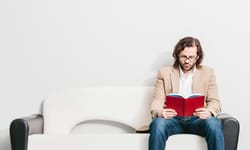 Young Man Reading a Book in a Waiting Room