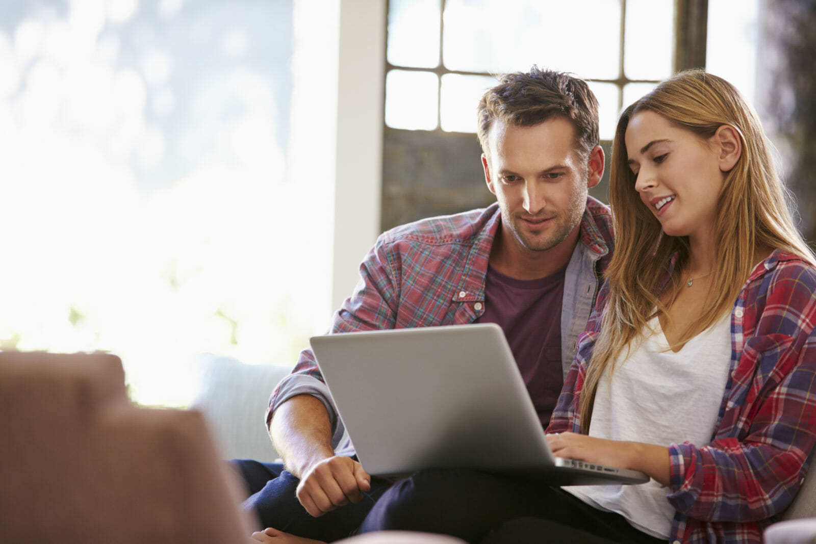 Couple At Home In Lounge Using Laptop Computer